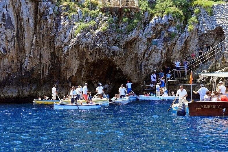 Tour boats and rowboats waiting their turn at the mouth of the Blue Grotto