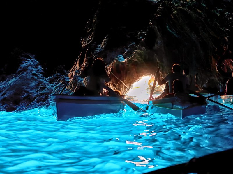 Rowboats silhouetted against the bright opening of the Blue Grotto