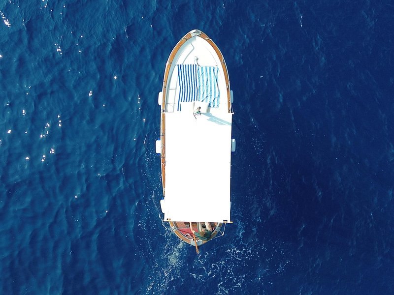 A rowing boat photographed from directly above on deep blue water