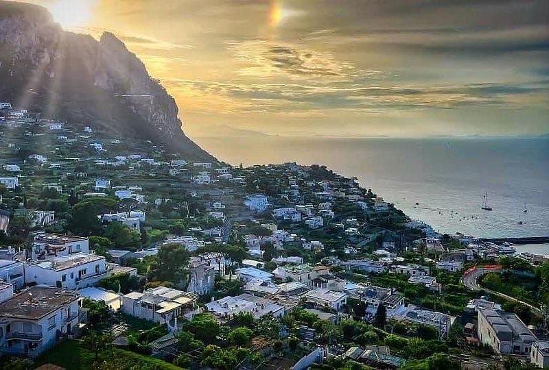 Capri town spread across the saddle of the island in late afternoon light